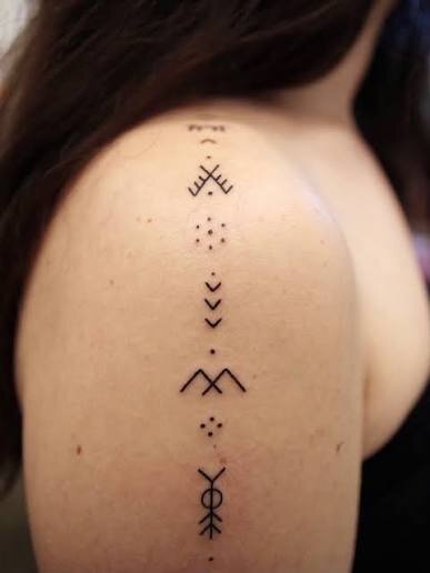 deq signs tattooed down the upper arm
